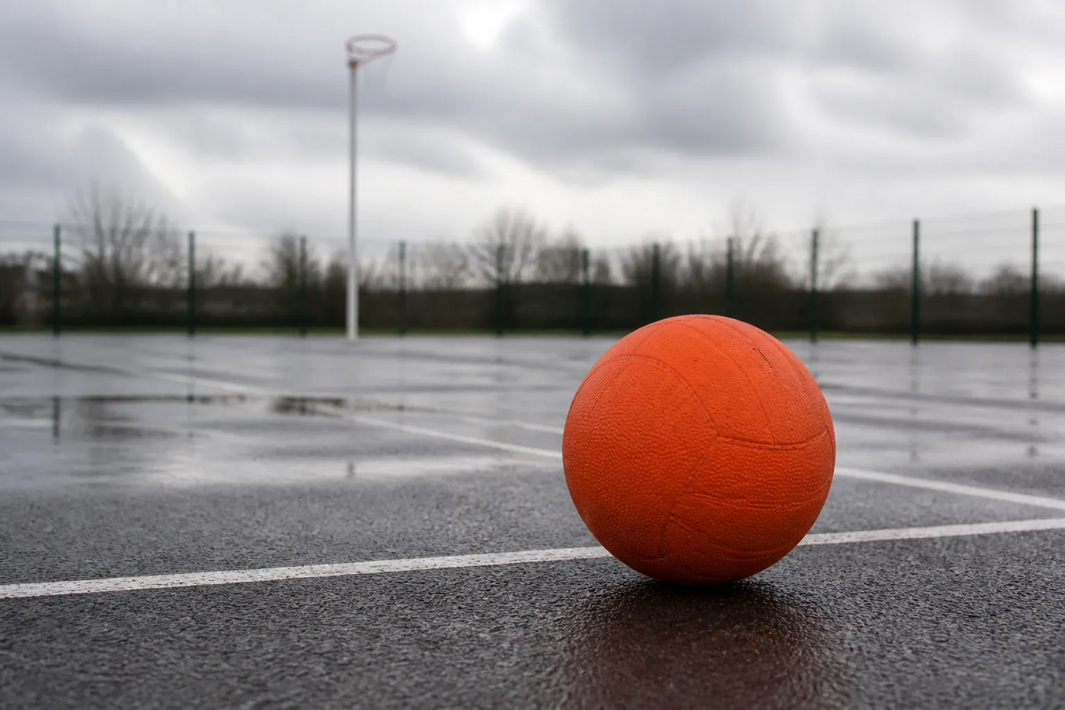 A netball on a wet outdoor court