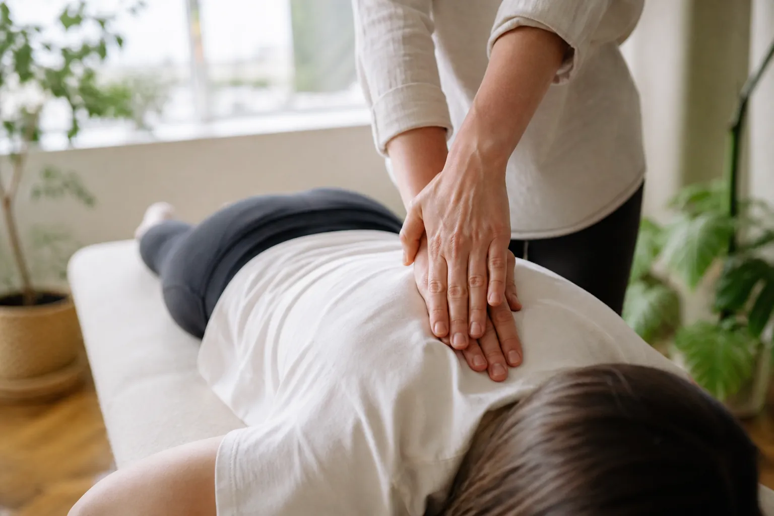 Hands-on osteopathic treatment of the back in a bright clinic